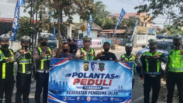 Personel Satlantas Polres Lahat membagikan masker kepada pengguna jalan di Kota Lahat saat dampak kabut asap karhutla.