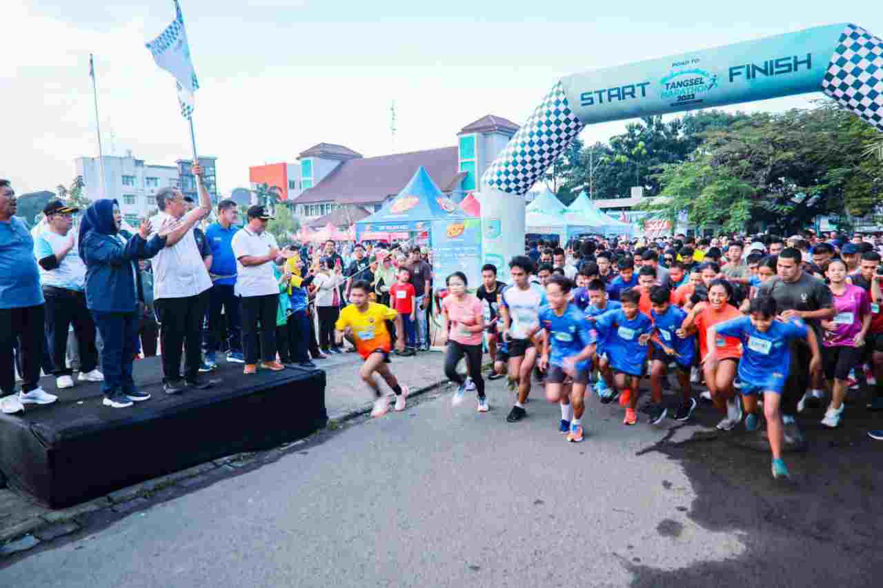 Wali Kota Tangsel Benyamin Davnie (mengangkat bendera) saat melepas peserta Road to Tangsel Marathon di Kecamatan Pamulang, Minggu (9/7/2023).
