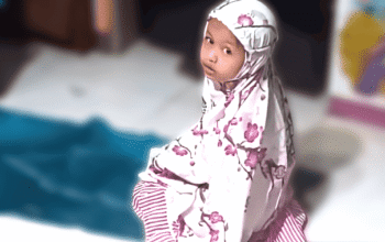 Ayah Muslim membimbing anak perempuannya dalam shalat