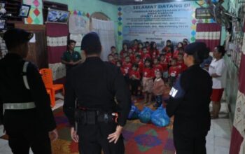 Personel Brimob Polda Sumut saat menyerahkan bantuan sembako dalam kegiatan Minggu Kasih