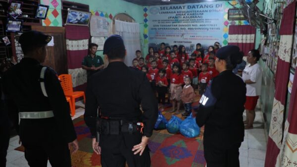 Personel Brimob Polda Sumut saat menyerahkan bantuan sembako dalam kegiatan Minggu Kasih