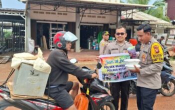 Personel Polsek Muara Pawan membagikan nasi kotak kepada pengendara
