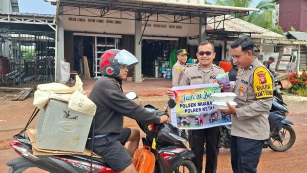 Personel Polsek Muara Pawan membagikan nasi kotak kepada pengendara