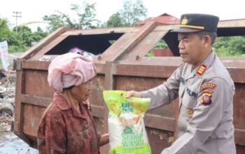 Personel Polres Ketapang membagikan paket sembako dalam program Jumat Berkah.