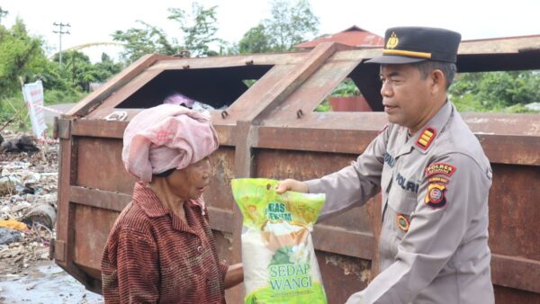Personel Polres Ketapang membagikan paket sembako dalam program Jumat Berkah.