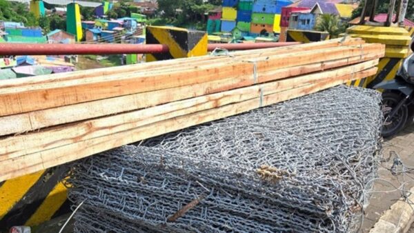 Petugas memeriksa lokasi longsor oprit Jembatan Brantas di Kota Malang