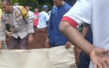 Aipda Sri Eka B membantu proses pemakaman warga di Desa Pejamben Carita Pandeglang