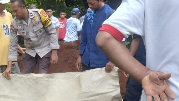 Aipda Sri Eka B membantu proses pemakaman warga di Desa Pejamben Carita Pandeglang