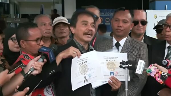 Roy Suryo menunjukkan scan ijazah Jokowi dan ijazah asli UGM saat hadir di Polda Metro Jaya