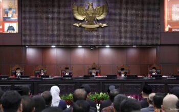 Logo Mahkamah Konstitusi Indonesia dengan latar pers dan kamera wartawan