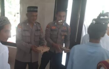 Polisi berbagi nasi kotak kepada jamaah usai salat Jumat di Rangkasbitung