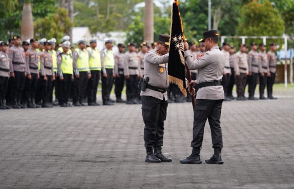 MANOKWARI — Kepolisian Daerah (Polda) Papua Barat menggelar parade penyambutan Kapolda Papua Barat yang baru Brigjen Pol Alfred Papare, S.I.K., sekaligus pelepasan Kapolda lama Irjen Pol Johnny Eddizon Isir, S.I.K., M.T.C.P. yang selanjutnya mengemban amanah sebagai Kepala Divisi Humas Polri. Kegiatan tersebut berlangsung di Mapolda Papua Barat, Manokwari, Jumat (6/2/2026). Dalam acara itu, Kapolda baru hadir bersama Ketua Bhayangkari Daerah Papua Barat Ny. Riris Alfred, sedangkan Kapolda lama hadir bersama istri Ny. Astrid Isir. Penyambutan dipimpin langsung oleh Wakapolda Papua Barat Brigjen Pol Dr. Sulastiana, M.Si. dan dihadiri para Pejabat Utama (PJU), Kapolres jajaran, serta personel Polda Papua Barat. Prosesi penyambutan ditandai dengan pengalungan tas noken dan tradisi injak piring sebagai bentuk penghormatan sekaligus pelestarian kearifan lokal Papua Barat. Setelah menerima jajar hormat, Kapolda baru dan istri berjalan melewati barisan kehormatan menuju pintu utama Mapolda. Setibanya di teras utama, Irjen Pol Johnny Eddizon Isir menyambut kedatangan Brigjen Pol Alfred Papare. “Selamat datang kembali di Polda Papua Barat sebagai Kapolda,” ujar Johnny Isir. Usai rangkaian penyambutan, kegiatan dilanjutkan dengan laporan satuan oleh Wakapolda Papua Barat kepada Kapolda baru sebagai bagian dari penyampaian gambaran situasi dan kondisi satuan. Selanjutnya dilaksanakan serah terima Ketua Bhayangkari Daerah Papua Barat dari Ny. Astrid Isir kepada Ny. Riris Alfred. Rangkaian acara kemudian dilanjutkan dengan apel satuan upacara penyerahan Pataka “Waaja Keema Nenekapoka” sebagai simbol penyerahan kepemimpinan dari Kapolda lama kepada Kapolda baru. Sebagai penutup, dilaksanakan tradisi pelepasan Irjen Pol Johnny Eddizon Isir yang diawali dengan pengalungan bunga dan dilanjutkan tradisi Pedang Pora sebagai bentuk penghormatan atas pengabdian selama menjabat Kapolda Papua Barat. Kepala Bidang Humas Polda Papua Barat Kombes Pol Ignatius Benny Ady Prabowo mengatakan kegiatan tersebut merupakan bentuk penerimaan resmi bagi Kapolda Papua Barat yang baru sekaligus penghormatan institusi kepada pejabat lama. “Kegiatan ini merupakan bentuk penghormatan dan penerimaan resmi kepada Kapolda Papua Barat yang baru, sekaligus apresiasi kepada pejabat lama atas pengabdian dan kinerja selama menjabat, sebelum mengemban amanah baru sebagai Kepala Divisi Humas Polri,” ujarnya.