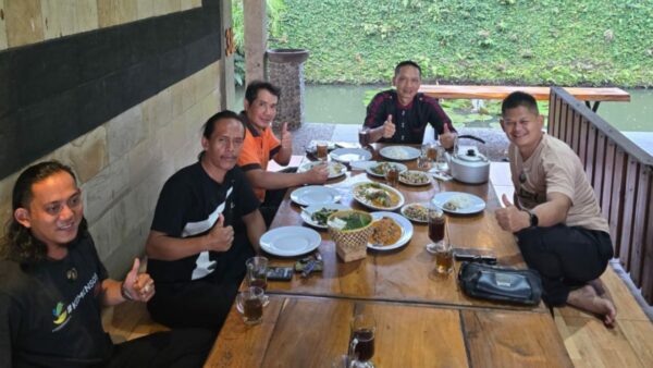 Ilustrasi sekelompok masyarakat saling berjabat tangan dalam suasana silaturahmi yang hangat sebagai simbol kohesi sosial.