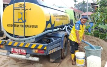 Alat berat Kementerian PU membersihkan lumpur dan material banjir di kawasan perkantoran Arosuka Kabupaten Solok.