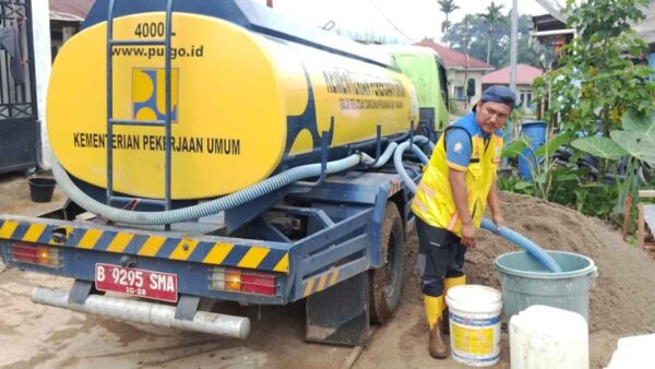Alat berat Kementerian PU membersihkan lumpur dan material banjir di kawasan perkantoran Arosuka Kabupaten Solok.