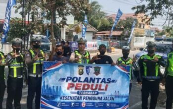 Personel Satlantas Polres Lahat membagikan masker kepada pengguna jalan di Kota Lahat saat dampak kabut asap karhutla.